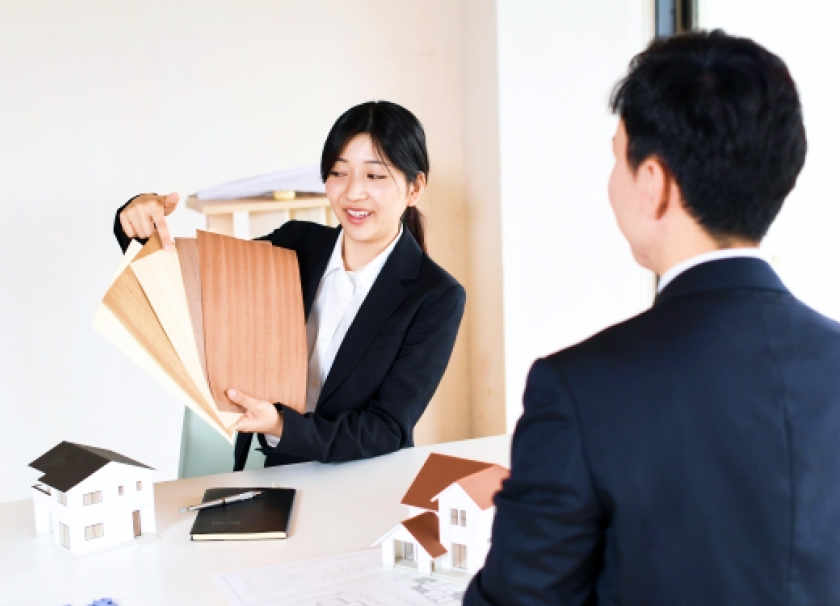 画像：クライアントに資料を提示する女性社員